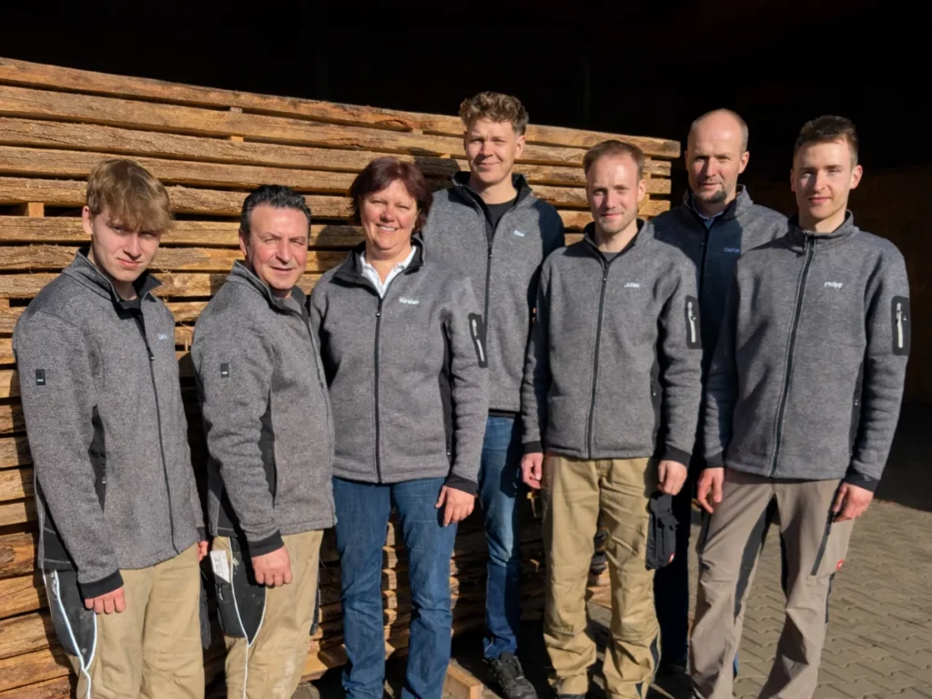 Das Team von Zimmermann Möbelbau vor dem Holzlager
