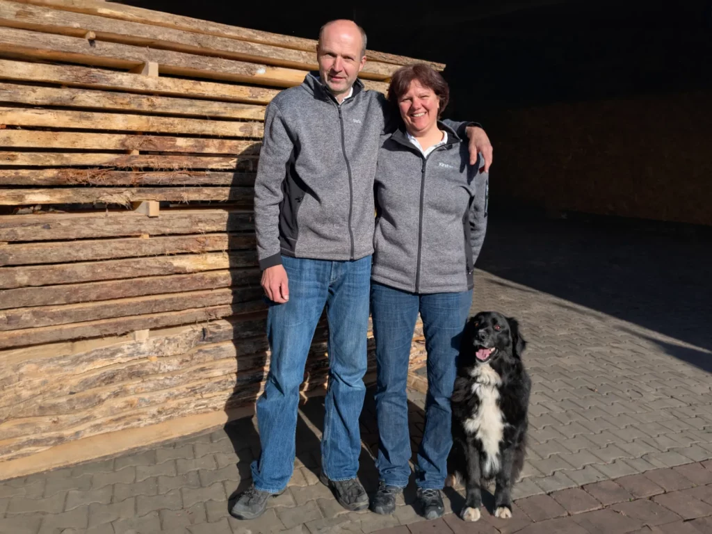 Kirsten und Stefan Zimmermann mit Hund vor dem Holzlager