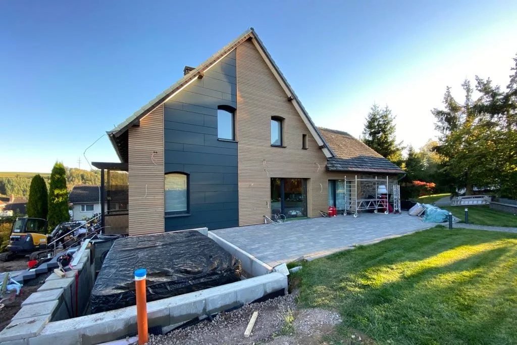 Fertige Fassade aus Lärche und anthrazitfarbenen Trespa-Platten an einem Wohnhaus in Korbach